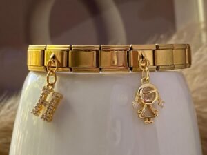 Pulsera italiana dorada con dos dijes de acero inoxidable con baño de oro de 18k