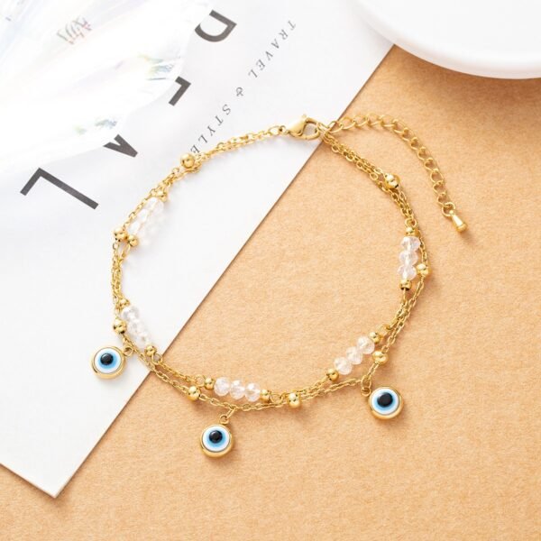 Pulsera doble cadena con dijes de ojos turcos colgantes y borlas blancas de acero inoxidable