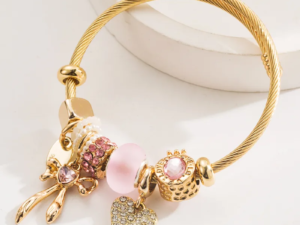 Pulsera dorada estilo pandora borlas rosa, moña y corazón acero inoxidable y charms de aleación