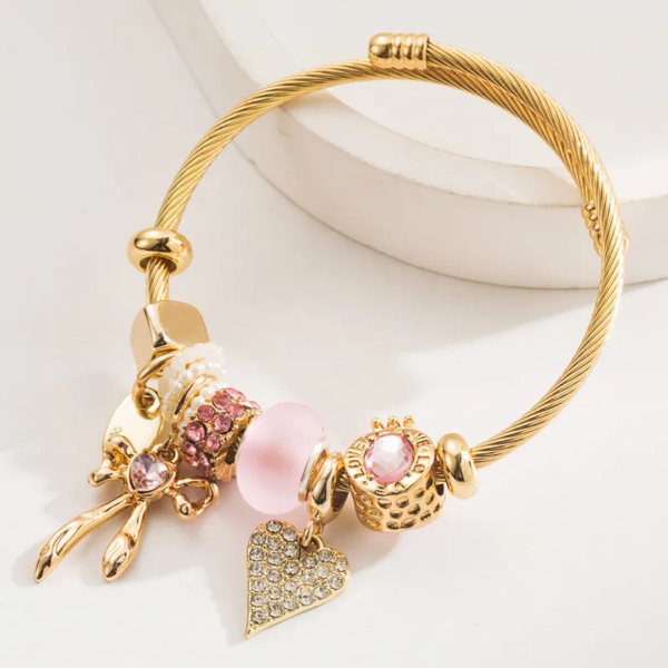Pulsera dorada estilo pandora borlas rosa, moña y corazón acero inoxidable y charms de aleación